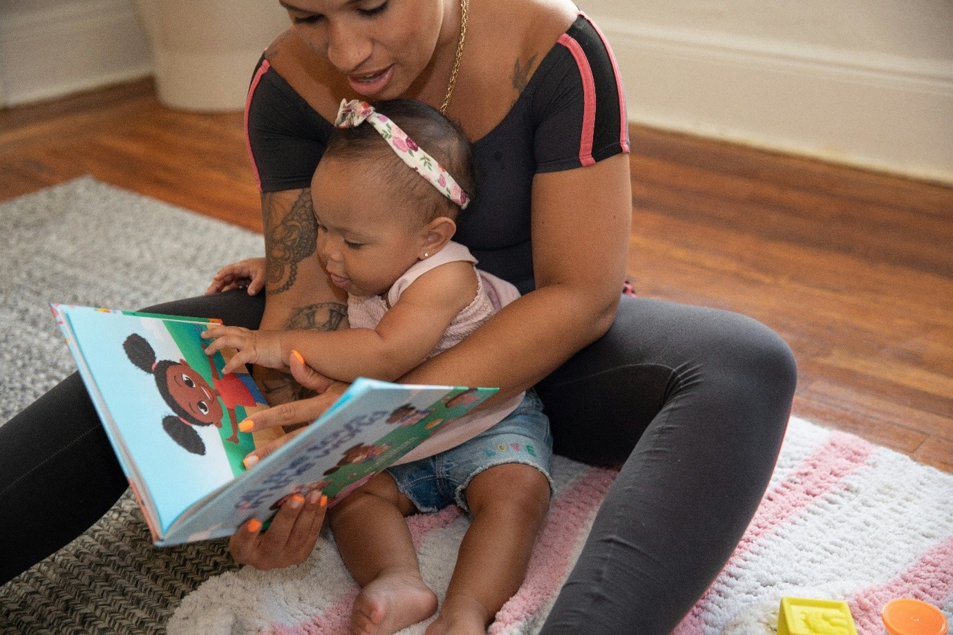 Women reading a child's book to a toddler