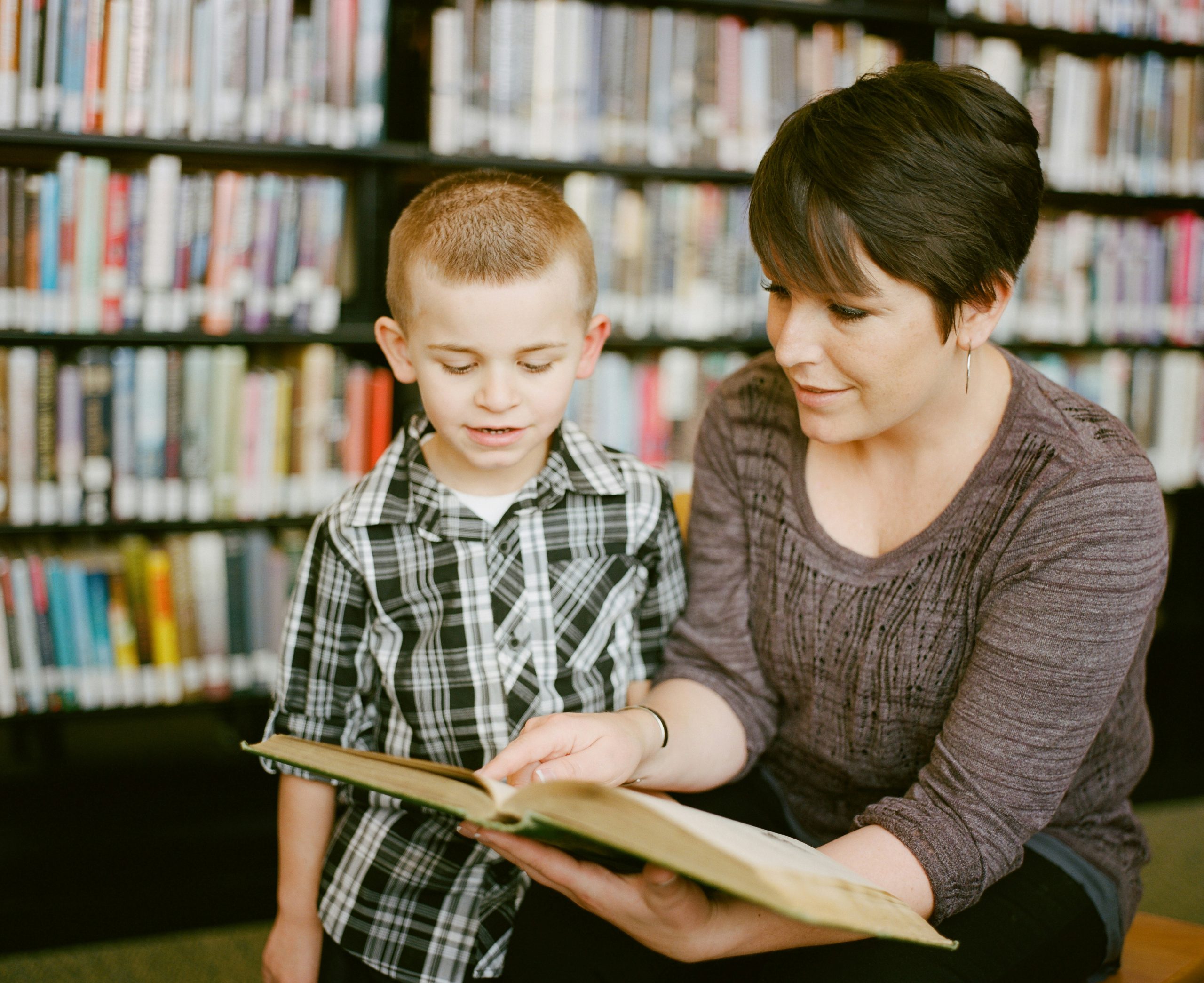 Teacher reading to young boy as he listens intently